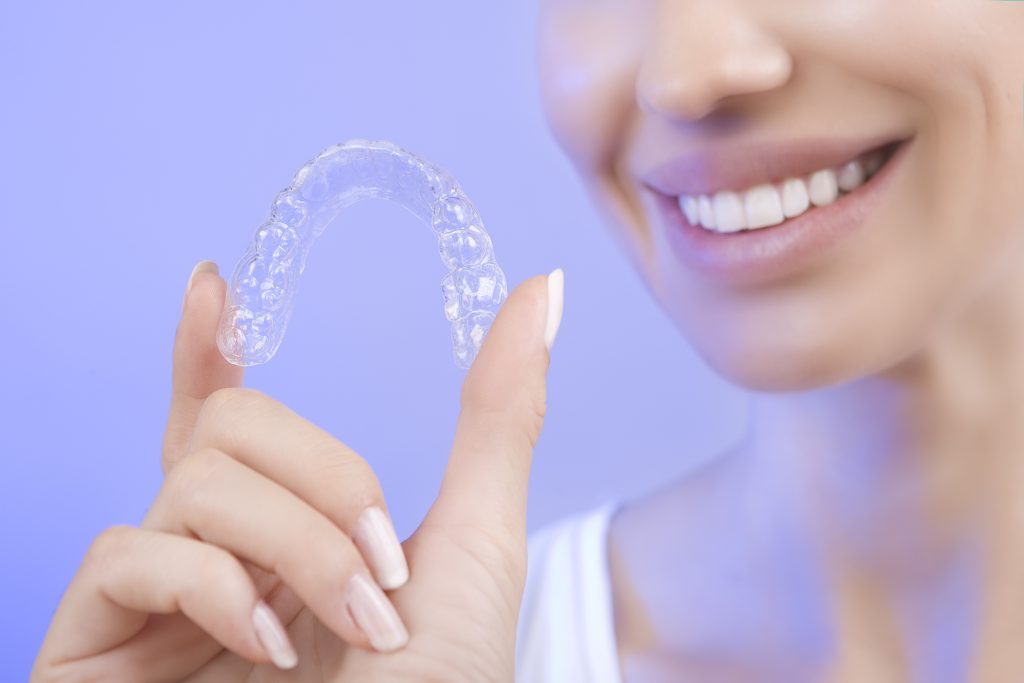 Beautiful Smiling Girl with Tooth Tray (hands Holding Individual Tooth Tray), Methods of Teeth Teeth Whitening and Correction, Close-up (blue filter effect)